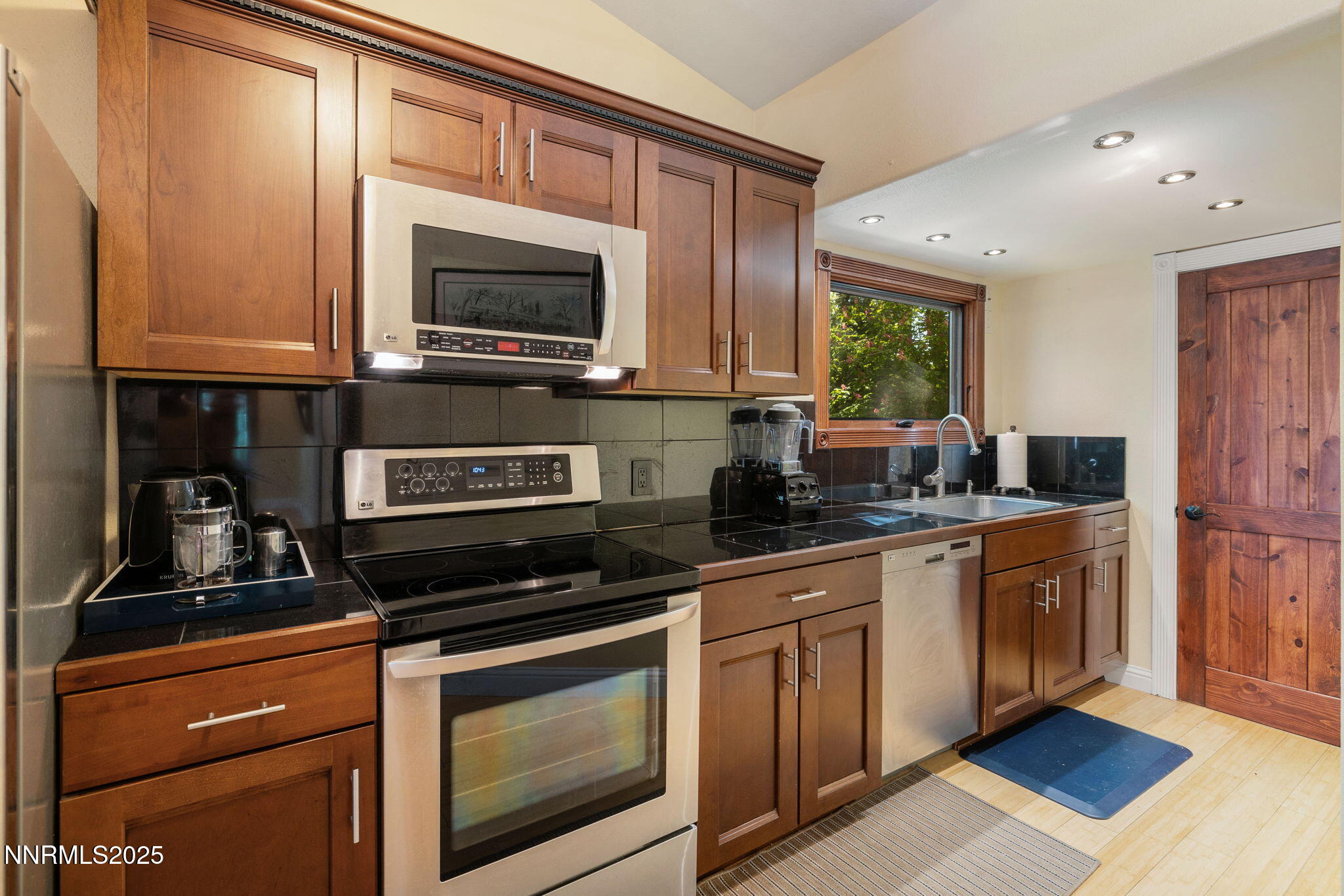 1555 Marsh Avenue Reno, NV 89509 - Photo 64 of 84 a kitchen with stainless steel appliances a stove a microwave a sink and cabinets