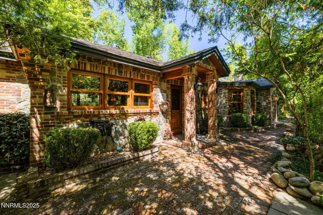 a living room with furniture a large window and wooden floor