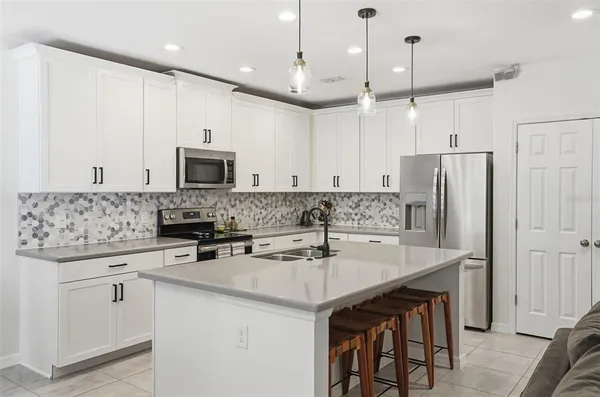 a kitchen with kitchen island a sink stainless steel appliances and cabinets