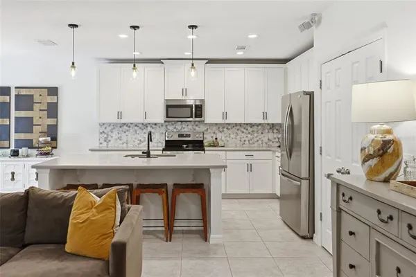 a kitchen with stainless steel appliances kitchen island granite countertop a refrigerator and a stove top oven
