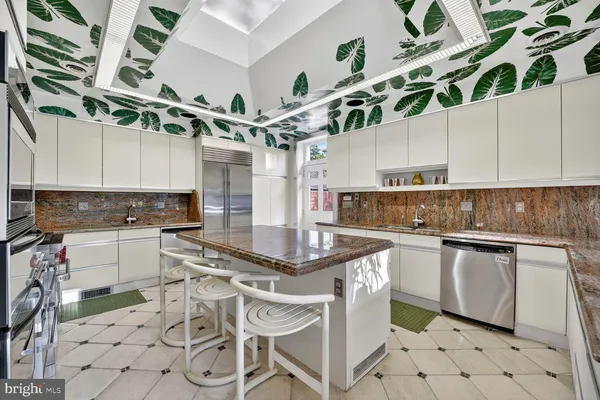 a kitchen with stainless steel appliances granite countertop a sink a stove and cabinets