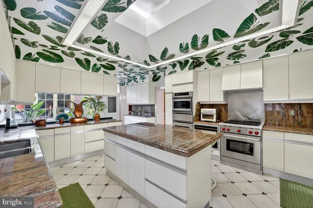 a kitchen with stainless steel appliances granite countertop a sink a stove and cabinets