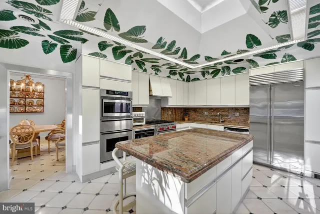 a kitchen with stainless steel appliances granite countertop a sink a stove and a wooden cabinets