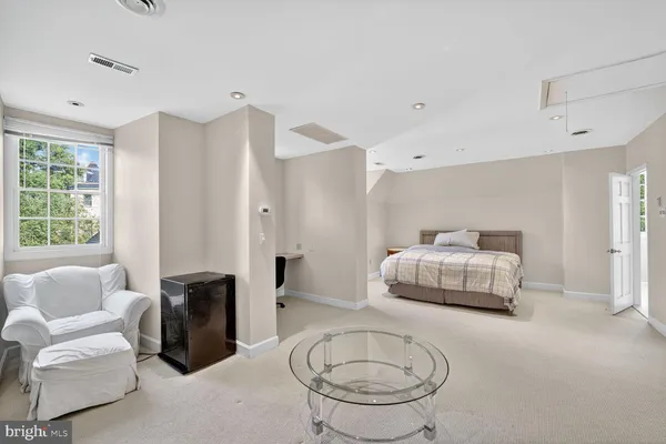 a bedroom with furniture and a large window