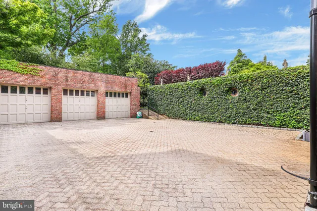 a front view of a building with a yard and trees
