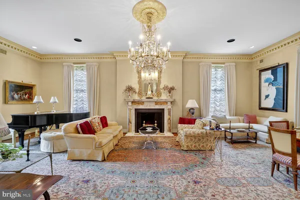 a living room with furniture a chandelier and a fireplace