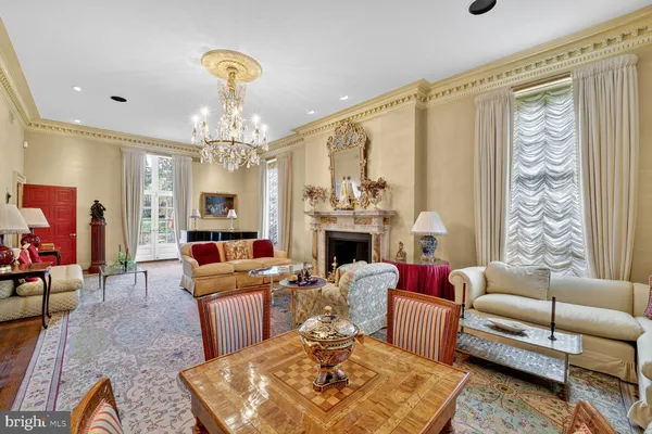 a living room with furniture a chandelier and a fireplace