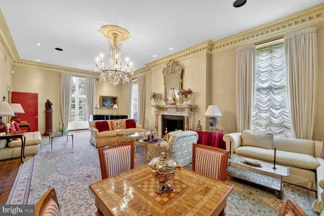 a living room with furniture a chandelier and a fireplace