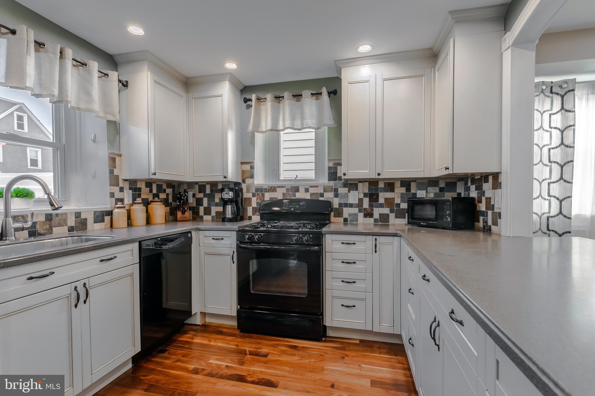34 Greenhill Road Springfield, PA 19064 - Photo 15 of 36 a kitchen with stainless steel appliances granite countertop a sink stove and cabinets