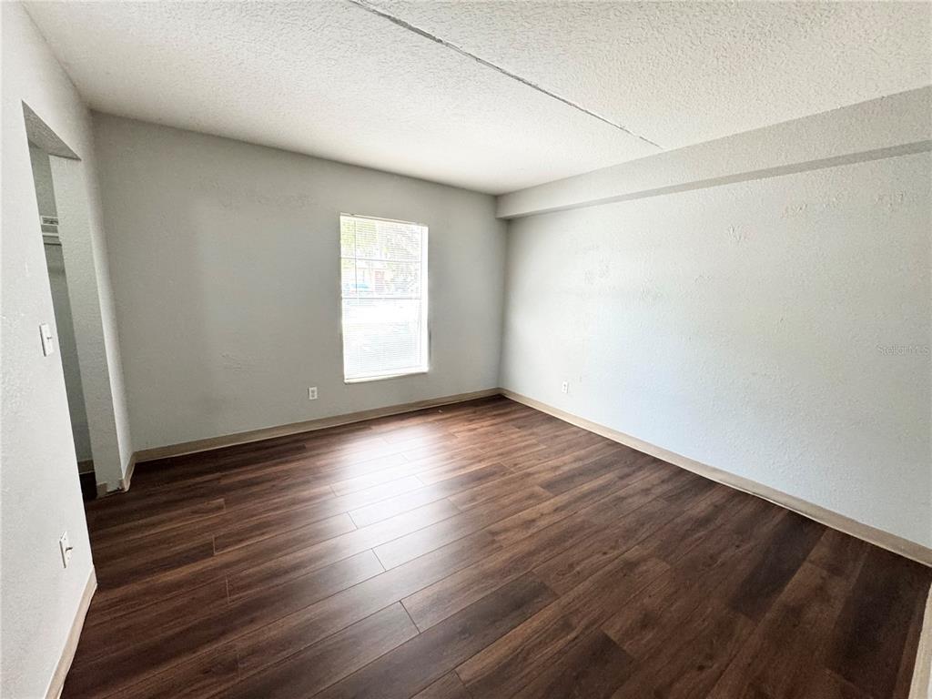 1229 Kennedy Road, Unit 69 Daytona Beach, FL 32117 - Photo 12 of 16 an empty room with wooden floor and windows