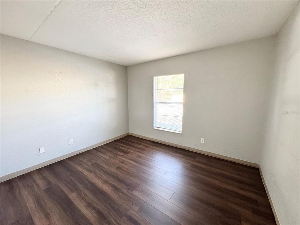1229 Kennedy Road, Unit 69 Daytona Beach, FL 32117 - Photo 7 of 16 an empty room with wooden floor and windows