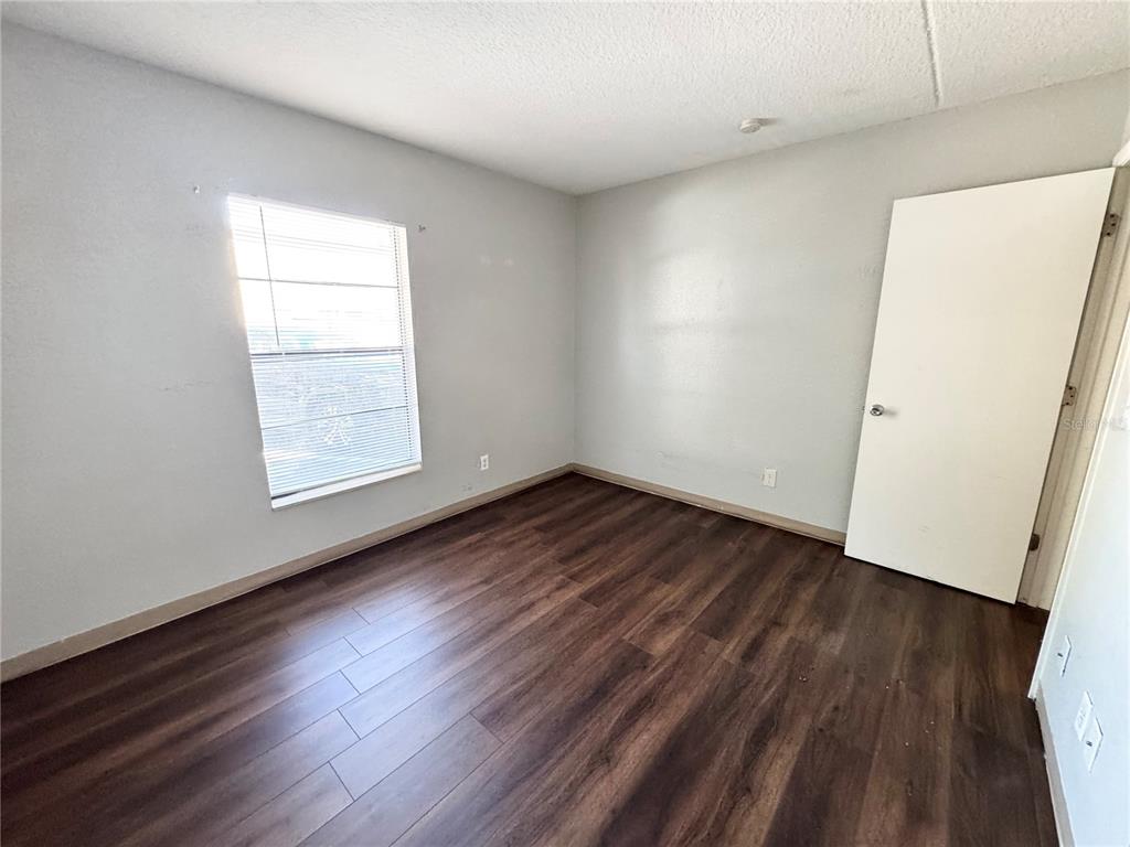 1229 Kennedy Road, Unit 69 Daytona Beach, FL 32117 - Photo 9 of 16 an empty room with wooden floor and windows