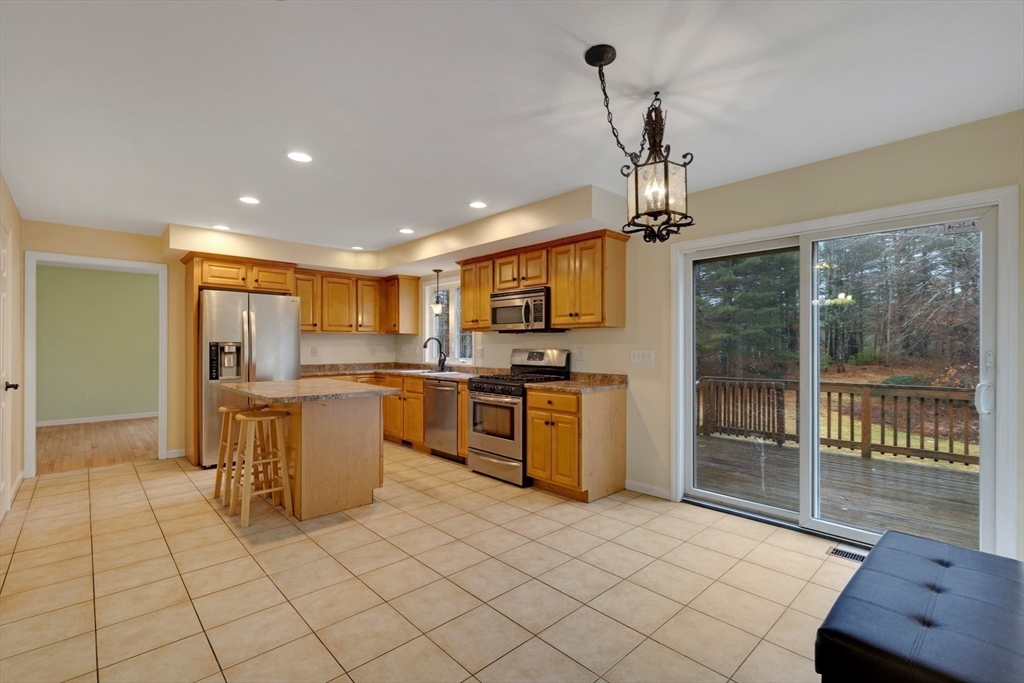 269 Tispaquin Street Middleboro, MA 02346 - Photo 11 of 40 a kitchen with a refrigerator a sink dishwasher with a dining table and chairs