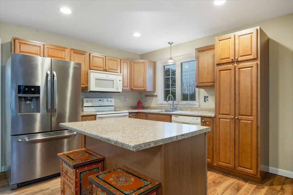269 Tispaquin Street Middleboro, MA 02346 - Photo 31 of 40 a kitchen with stainless steel appliances granite countertop a refrigerator a stove and a sink with wooden floor