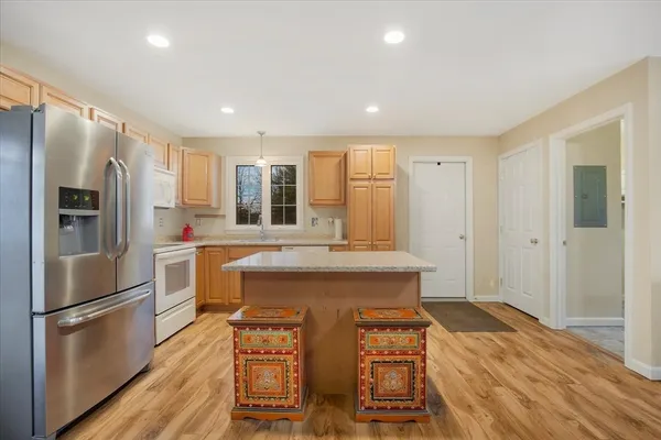 a kitchen with stainless steel appliances a refrigerator a stove a sink dishwasher and a refrigerator with wooden floor