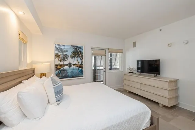 a bedroom with a bed and a flat screen tv