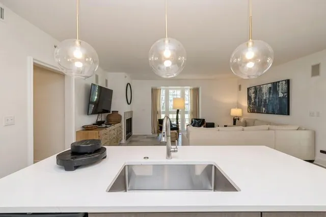 a kitchen with sink and a large mirror