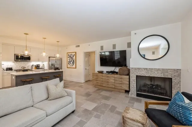 a living room with furniture a fireplace and a flat screen tv