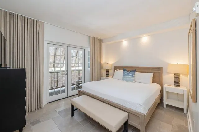 a large bedroom with a bed and large window