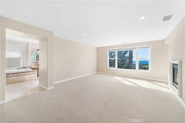 a view of empty room with wooden floor and a fireplace