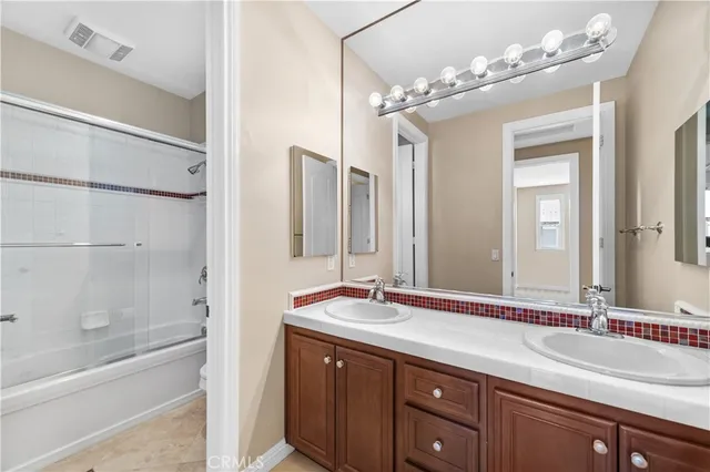 a bathroom with a double vanity sink mirror and bathtub