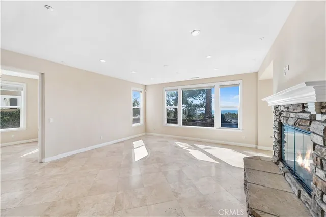 a view of an empty room with a fireplace and a window