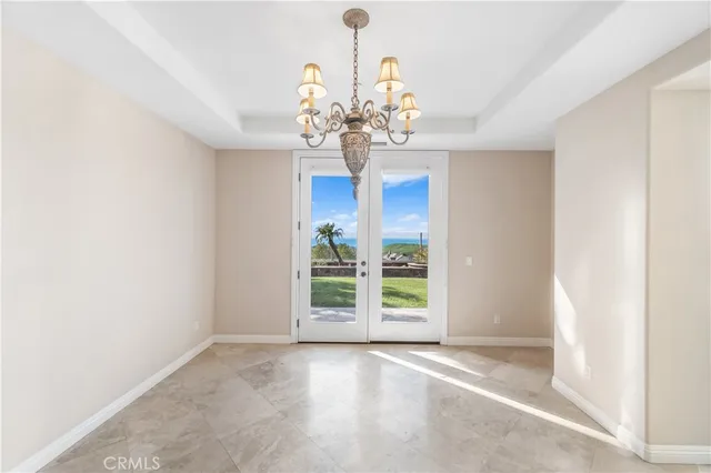 an empty room with windows and chandelier