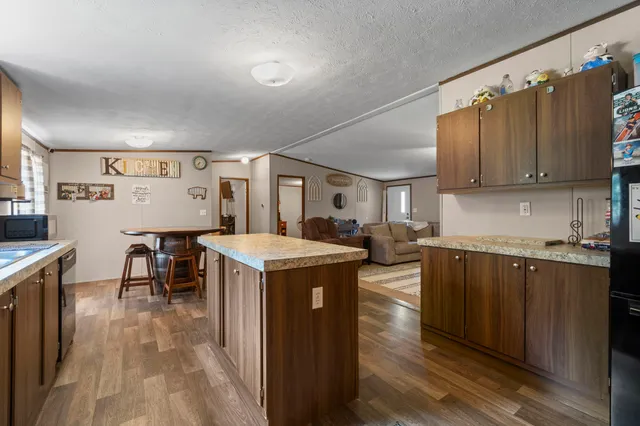 a kitchen with granite countertop a sink a counter top space and stainless steel appliances