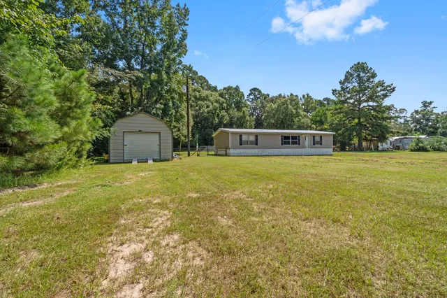 a view of a house with yard and sitting area