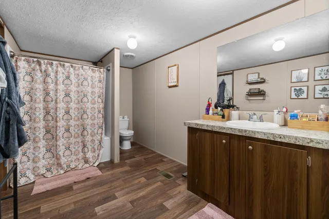 a spacious bathroom with a granite countertop sink and a mirror