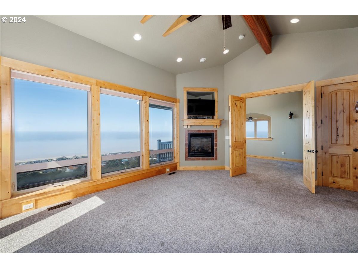 367 South Longview Loop Rockaway Beach, OR 97136 - Photo 19 of 43 a view of an empty room with a fireplace and a floor to ceiling window