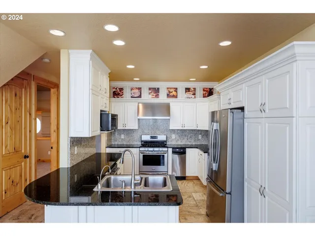 a kitchen with stainless steel appliances granite countertop a refrigerator and a stove