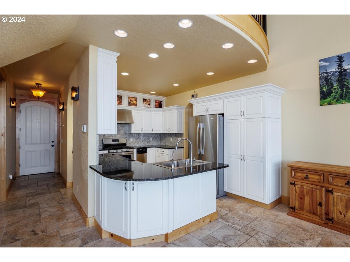 367 South Longview Loop Rockaway Beach, OR 97136 - Photo 26 of 43 a kitchen with stainless steel appliances granite countertop a sink a refrigerator and a stove