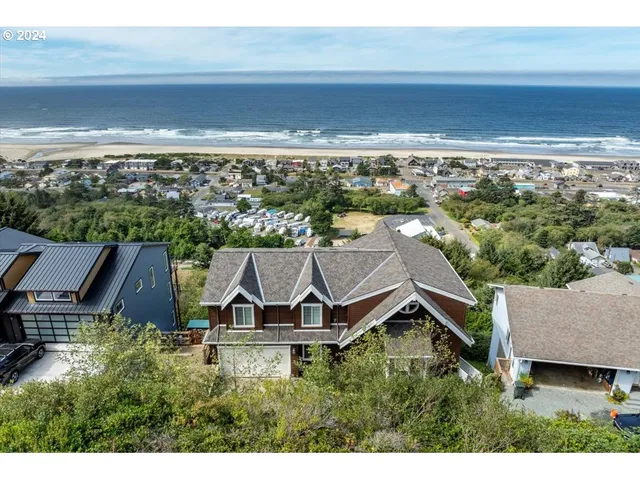 an aerial view of house with yard and ocean