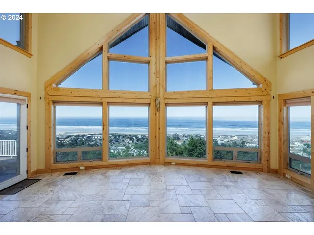 a view of an empty room with wooden floor and doors