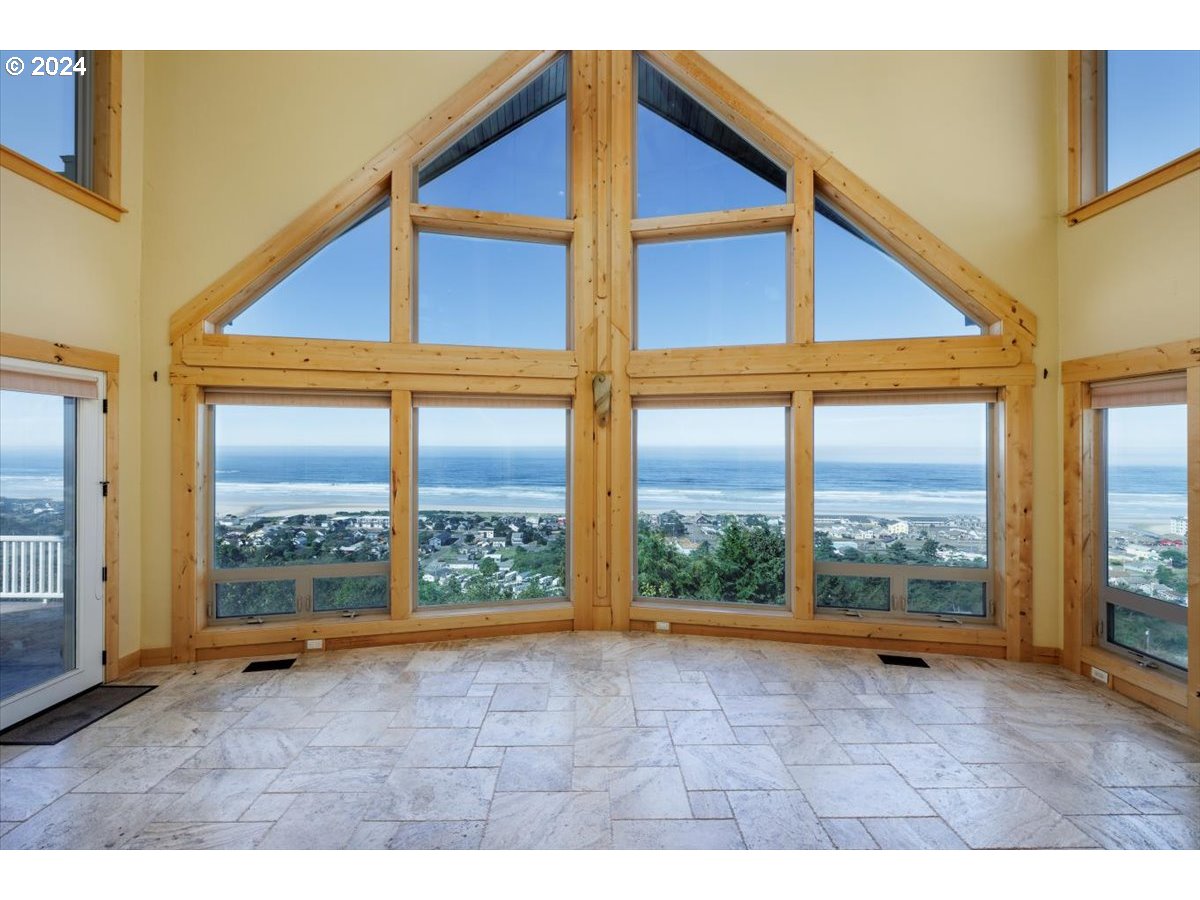 367 South Longview Loop Rockaway Beach, OR 97136 - Photo 9 of 43 a view of an empty room with wooden floor and doors