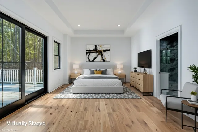 a spacious bedroom with a large bed and a flat screen tv