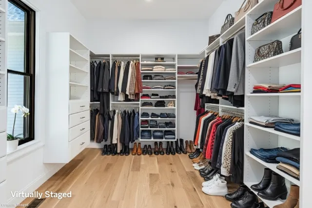 a view of walk in closet with clothes and shoes