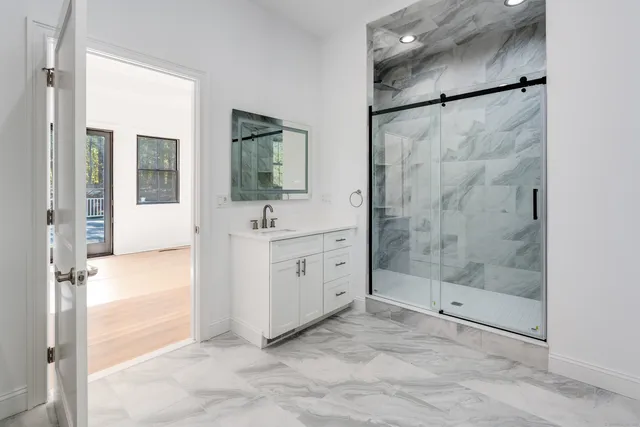 a bathroom with a shower sink and mirror