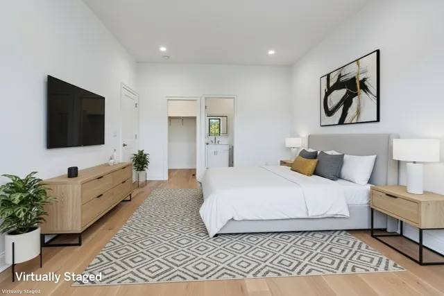 a spacious bedroom with a bed and a flat screen television
