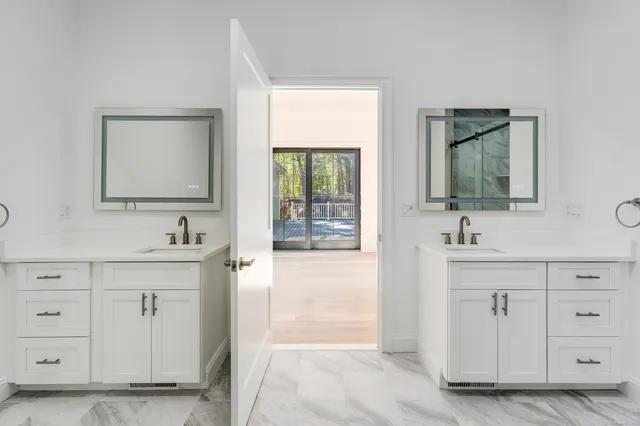 a bathroom with double vanity sink and a mirror