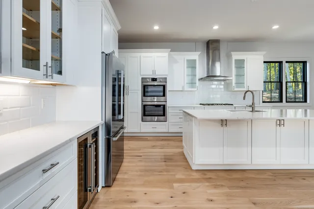 a kitchen with stainless steel appliances granite countertop a sink and a stove top oven