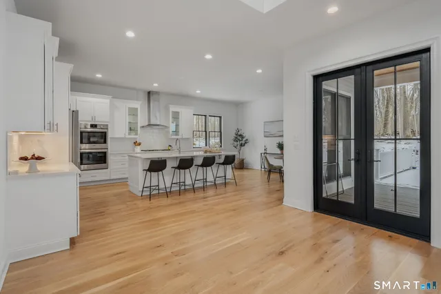 a kitchen with stainless steel appliances kitchen island granite countertop a refrigerator and a stove top oven