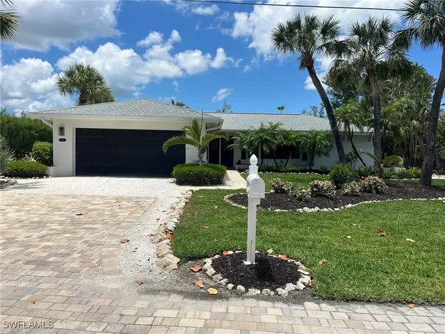 a front view of a house with a yard garage and outdoor seating