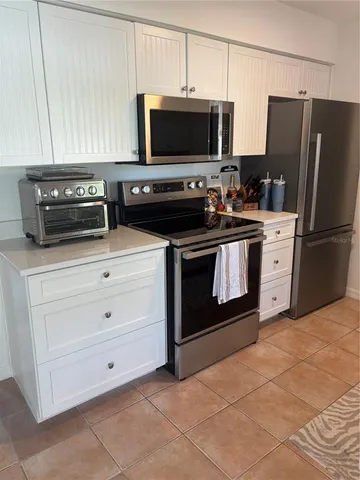 a kitchen with cabinets stainless steel appliances and a counter space