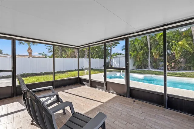 a view of an empty room with wooden floor and windows