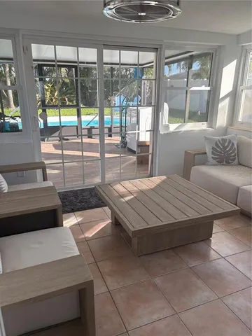 a living room with furniture and a floor to ceiling window