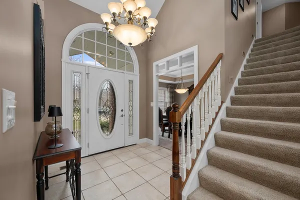 a view of hall way with furniture and chandelier