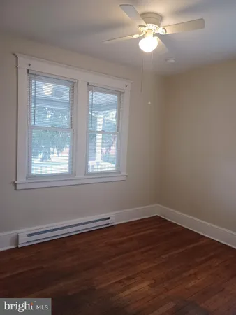 a view of a room with wooden floor a chandelier fan and windows