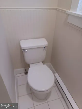 a white toilet sitting next to a shower